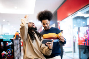 Brothers watching sports or playing on the smartphone at the mall